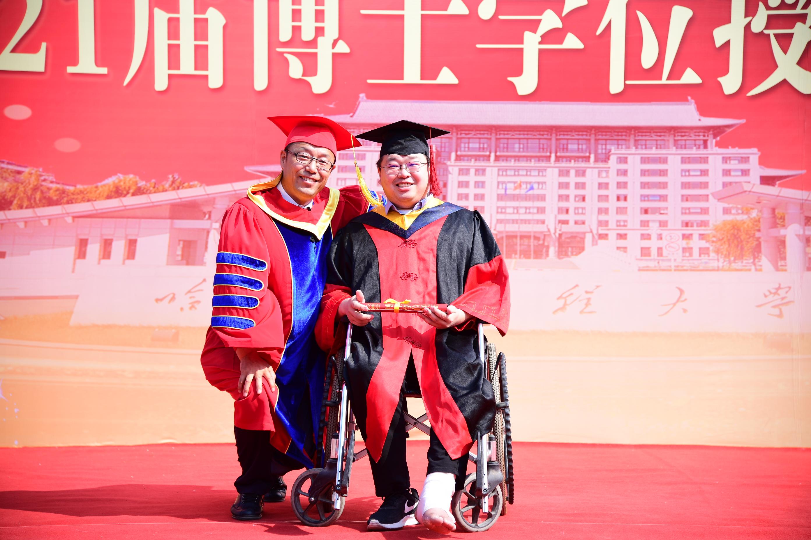 暖!校长单膝下蹲为"轮椅博士"拨穗